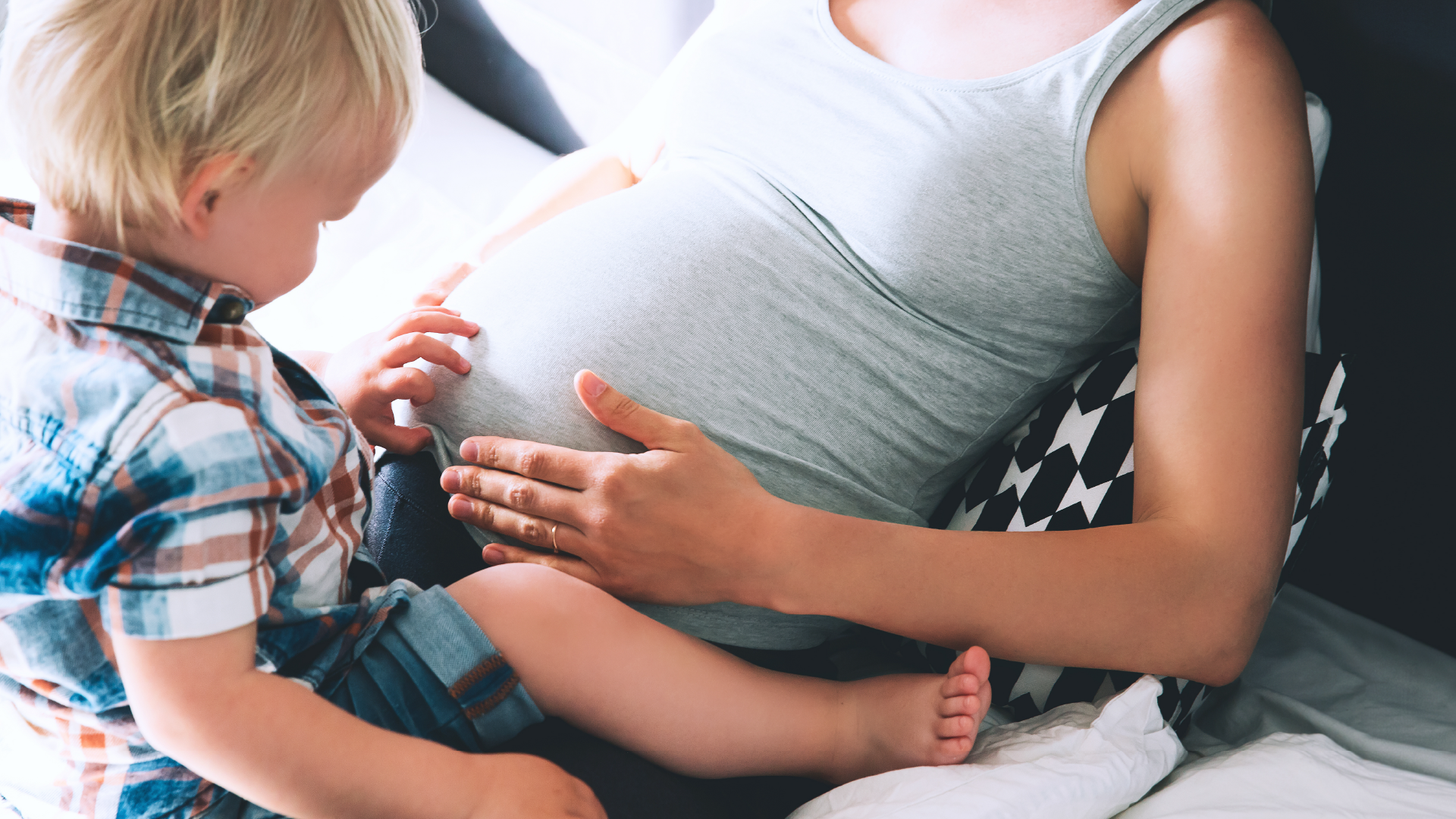 child sitting with pregnant belly